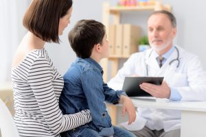 parent and child speaking to a doctor about bedwetting