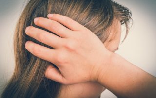A woman suffering from symptoms of Trigeminal Neuralgia, including nerve pain and facial pain. She is considering treatment for Trigeminal Neuralgia