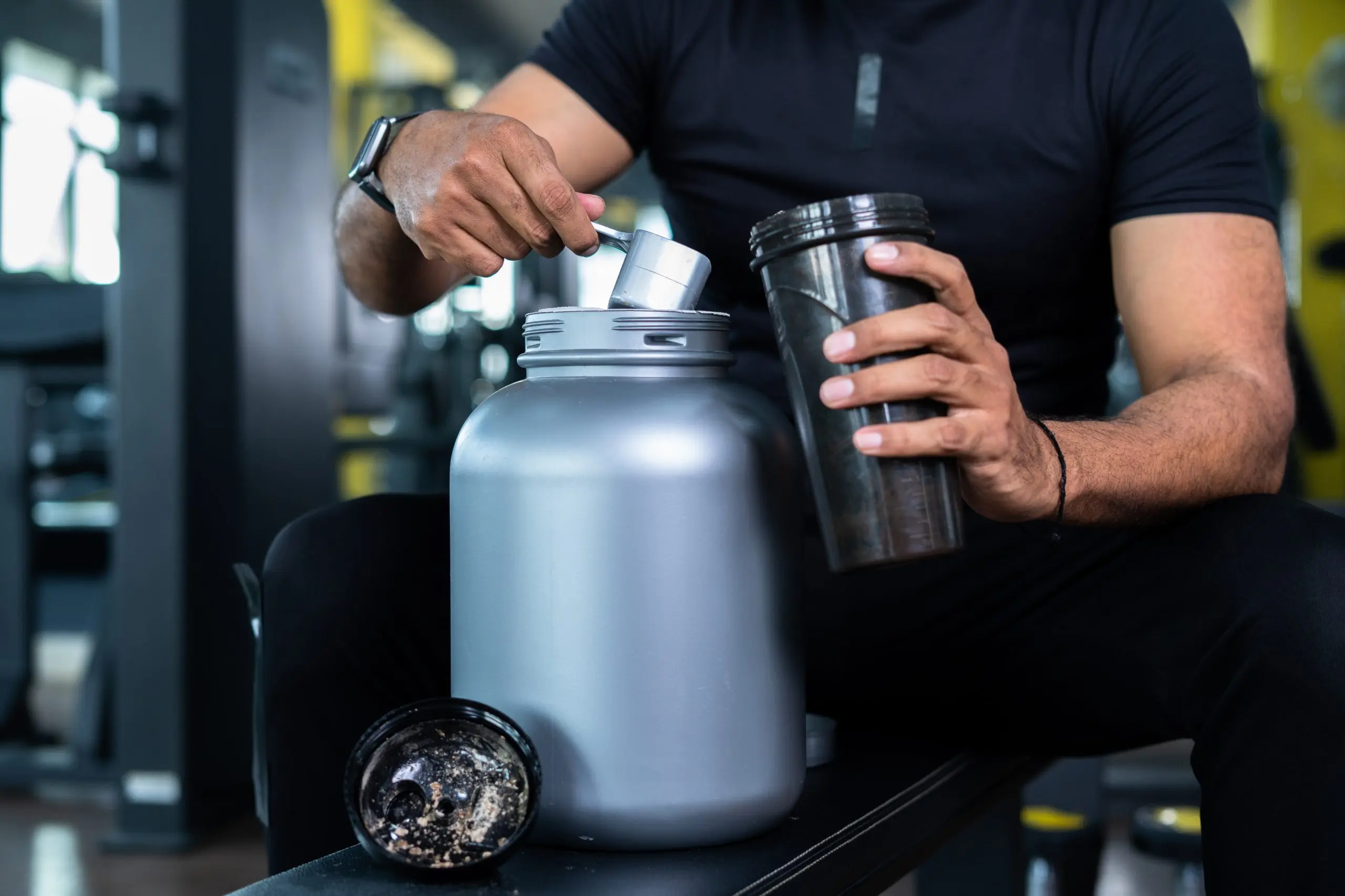 Close-up-shot-of-bodybuilder-hands-taking-protein-powder-scaled Close up shot of bodybuilder hands taking protein powder