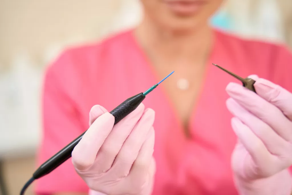 Female doctor holds scalpel in her hands to treat scrotal angiokeratoma