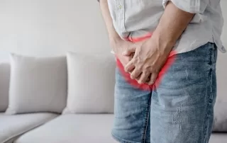 Male suffering from osteitis pubis holds his genitals with pain