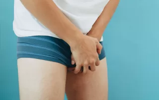 man with balanitis wearing underpants and holding genitals in discomfort